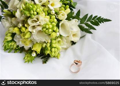 wedding bouquet and rings on white background