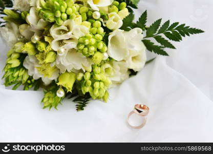 wedding bouquet and rings on white background