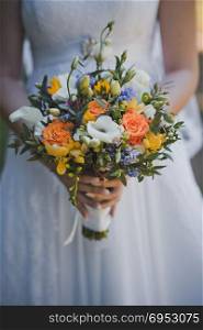 Wedding bouquet in a hand of the bride.