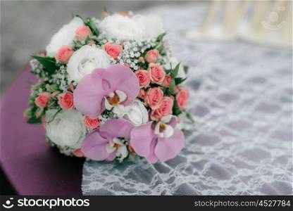 wedding bouquet of roses and orchids is on the table