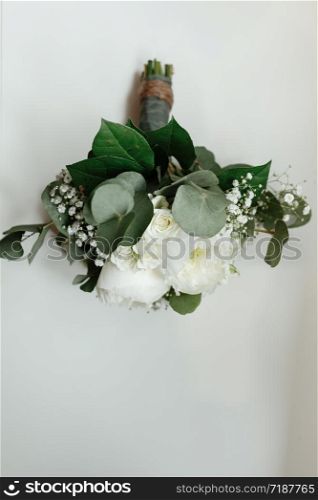 wedding bouquet of white roses and greens for the bride on a white table. bride morning. wedding accessories.. wedding bouquet of white roses and greens for the bride on a white table. bride morning. wedding accessories