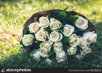 Wedding bouquet of white roses on green grass meadow