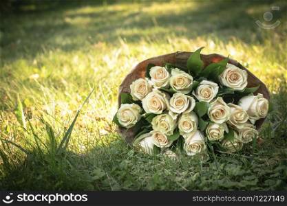 Wedding bouquet of white roses on green grass meadow