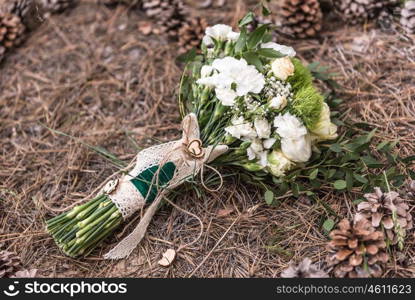 wedding bouquet on the ground on spruce litter around cones