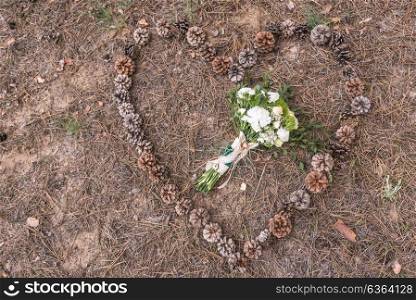 wedding bouquet on the ground on spruce litter around cones