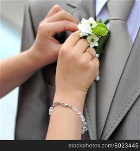 Wedding boutonniere placed on jacket of groom