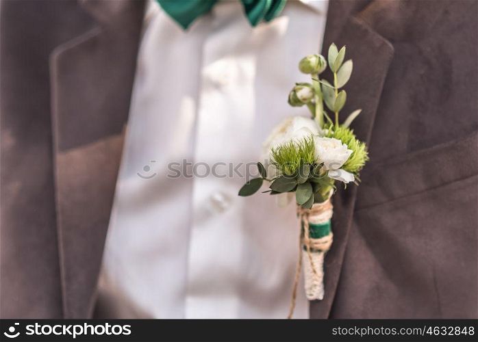 wedding boutonniere their flowers on the jacket of the groom