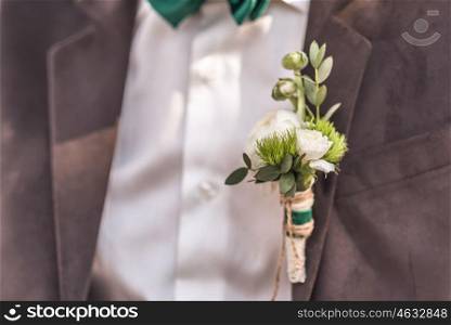 wedding boutonniere their flowers on the jacket of the groom