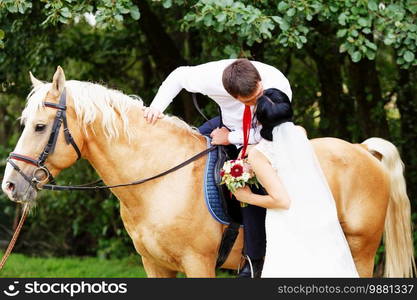 Wedding. Bride and groom with  horse. bride and groom on a horses in the forest