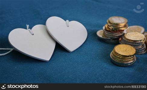 Wedding budget and couples finances concept with two hearts shape and coins stacks.