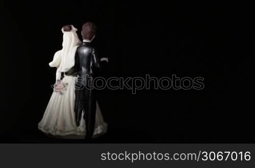 Wedding cake figurines rotation on black. Loop footage. Great for dvd menu background.