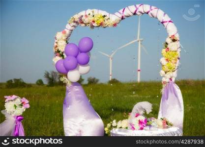 wedding ceremony in a field with windmills