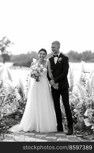 wedding ceremony on a high pier near the river with invited guests