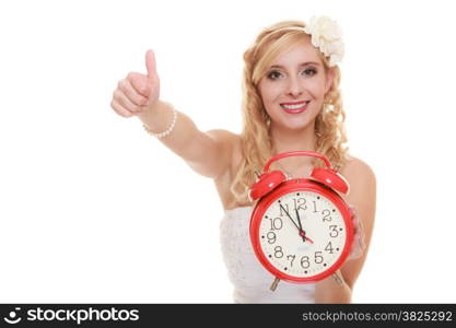 Wedding concept. Time to get married. Happy bride with red alarm clock showing thumb up hand sign gesture. Beautiful blonde woman waiting for the groom isolated on white