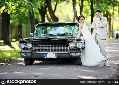 Wedding couple near car after their wedding ceremony