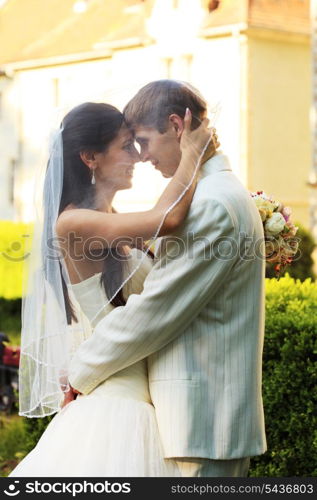 Wedding couple under veil are smiling outdoor