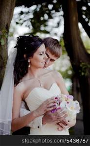 Wedding couple with bouquet outdoor