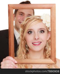 Wedding day. Portrait happy bride woman girl and groom man couple in wooden frame isolated on white. Studio shot.