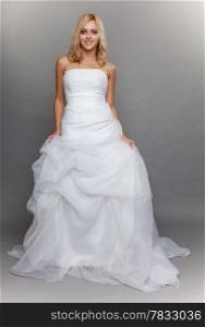 Wedding day. Portrait of happy beautiful blonde bride long white dress in full length studio shot on gray background