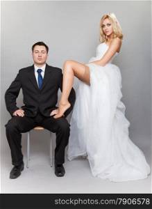 Wedding day. Portrait of happy married couple sexy blonde bride and groom in full length studio shot on gray background