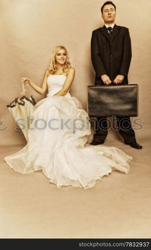 Wedding day. Portrait of married retro couple blonde bride with umbrella and groom with suitcase. Full length studio shot sepia color, vintage photo