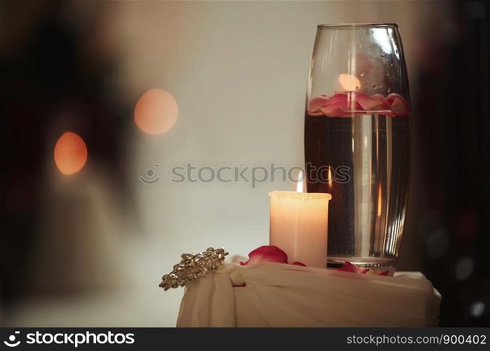 wedding decoration a candle and a vase with water on a white table. The vases with water and candles stand on the wedding table. wedding decoration a candle and a vase with water on a white table. Flasks with water and a floating candle