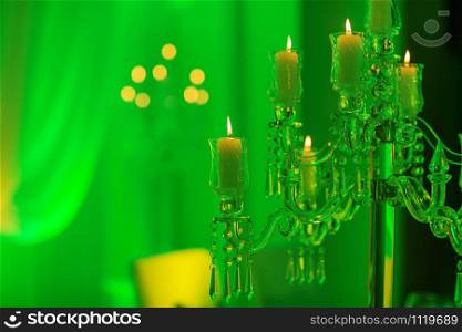 wedding decoration. crystal candelabra with candles in green light.. wedding decoration. crystal candelabra with candles in green light