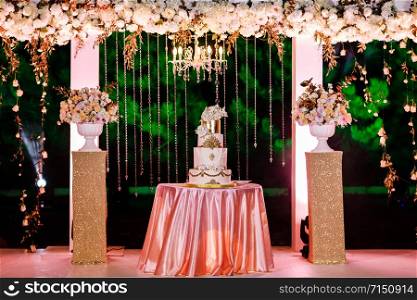 wedding decoration. Table with a wedding cake, candles, light and flowers.. Table with a wedding cake, candles, light and flowers. wedding decoration