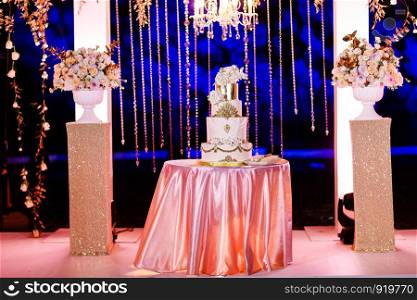 wedding decoration. Table with a wedding cake, candles, light and flowers.. Table with a wedding cake, candles, light and flowers. wedding decoration