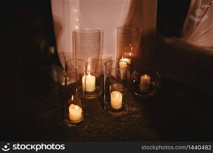 wedding decoration with candles lit and white fabric in the evening lights on dark background. selective focus.. wedding decoration with candles lit and white fabric in the evening lights on dark background. selective focus