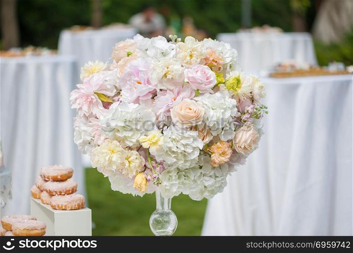 Wedding decoration with flowers on a table. Wedding decoration with flowers and food on a table outdoors
