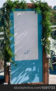 Wedding Event outdoor decoration setup, summer time, blue wooden screen with white paper copy space, white candles, copper candlesticks