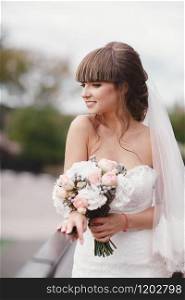 Wedding fashion bride with bouquet in hands. Young beautiful bride in an elegant dress with a bouquet at the wedding ceremony. Wedding fashion bride with bouquet in hands. Young beautiful bride in an elegant dress with a bouquet at the wedding ceremony.
