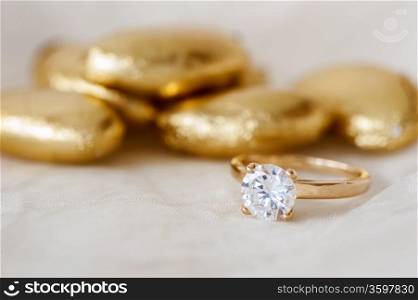 wedding favors and wedding ring on on colored background