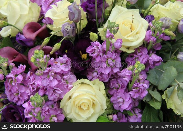 Wedding flower arrangement in white and purple, roses and calla lillies