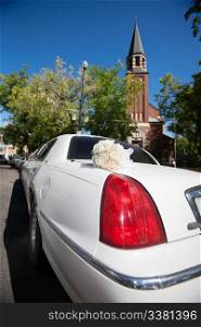 Wedding limo outside of church waiting for bridal couple