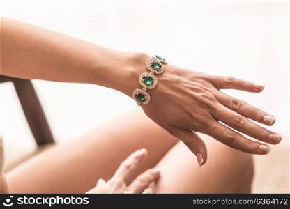 wedding manicure bride in gown, emerald jewelry bracelet