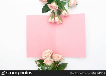 wedding or birthday mock up scene. Blank open sheet of paper with place for text for greeting card. Bouquet of pink roses on white background. Flat lay, top view.. wedding or birthday mock up scene. Blank open sheet of paper with place for text for greeting card. Bouquet of pink roses on white background. Flat lay, top view