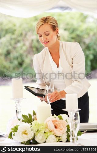 Wedding Planner Checking Table Decorations In Marquee