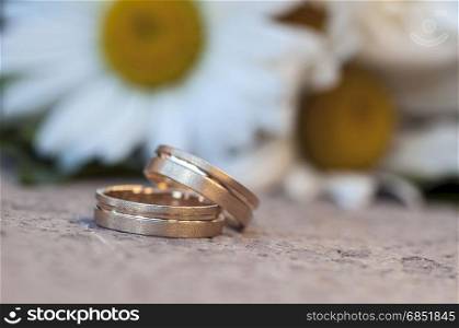 Wedding rigs in front of a wedding bouquet. Shallow depth of field