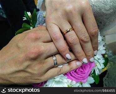 Wedding ring and two hands together over a pink bouquet. Love couple.. Wedding ring and two hands together over a pink bouquet.
