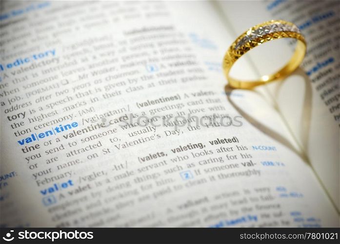 Wedding ring casting a heart onto a valentine word
