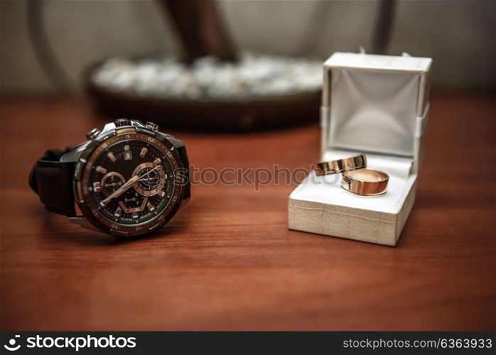 wedding ring in a box and watch the groom on the table