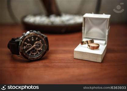 wedding ring in a box and watch the groom on the table