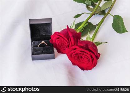 wedding ring with red roses white table