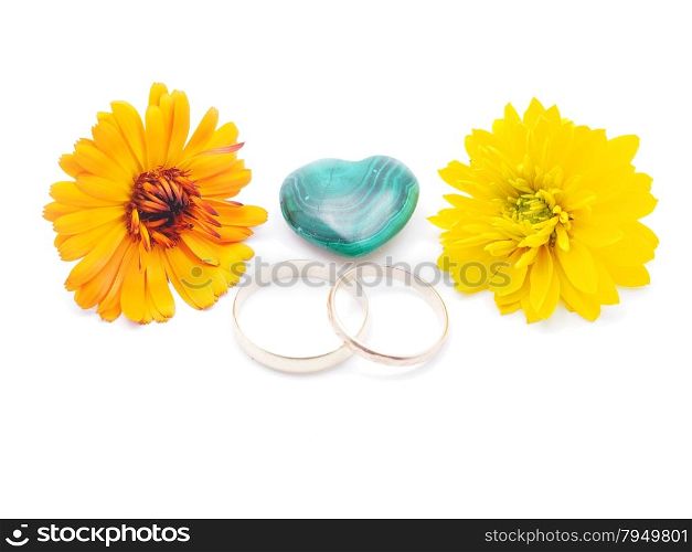 wedding rings, malachite heart and calendula on white background