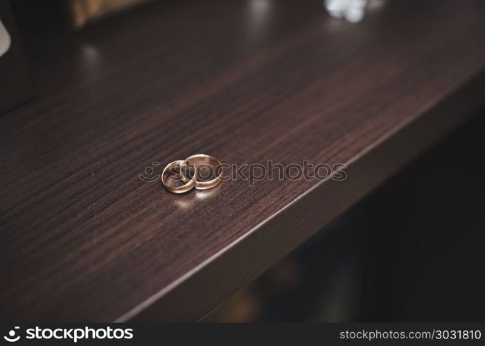 Wedding rings on a brown table.. Rings on a table.