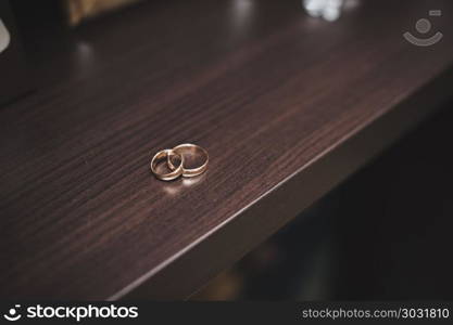 Wedding rings on a brown table.. Rings on a table.