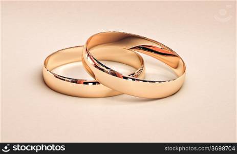 Wedding rings on a light background with reflections.