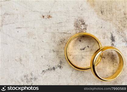 Wedding rings on dirty canvas with copy-space for text